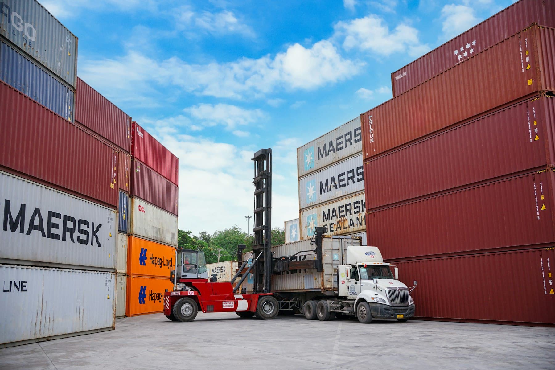 Chariot élévateur manœuvrant des conteneurs maritimes sur un terminal