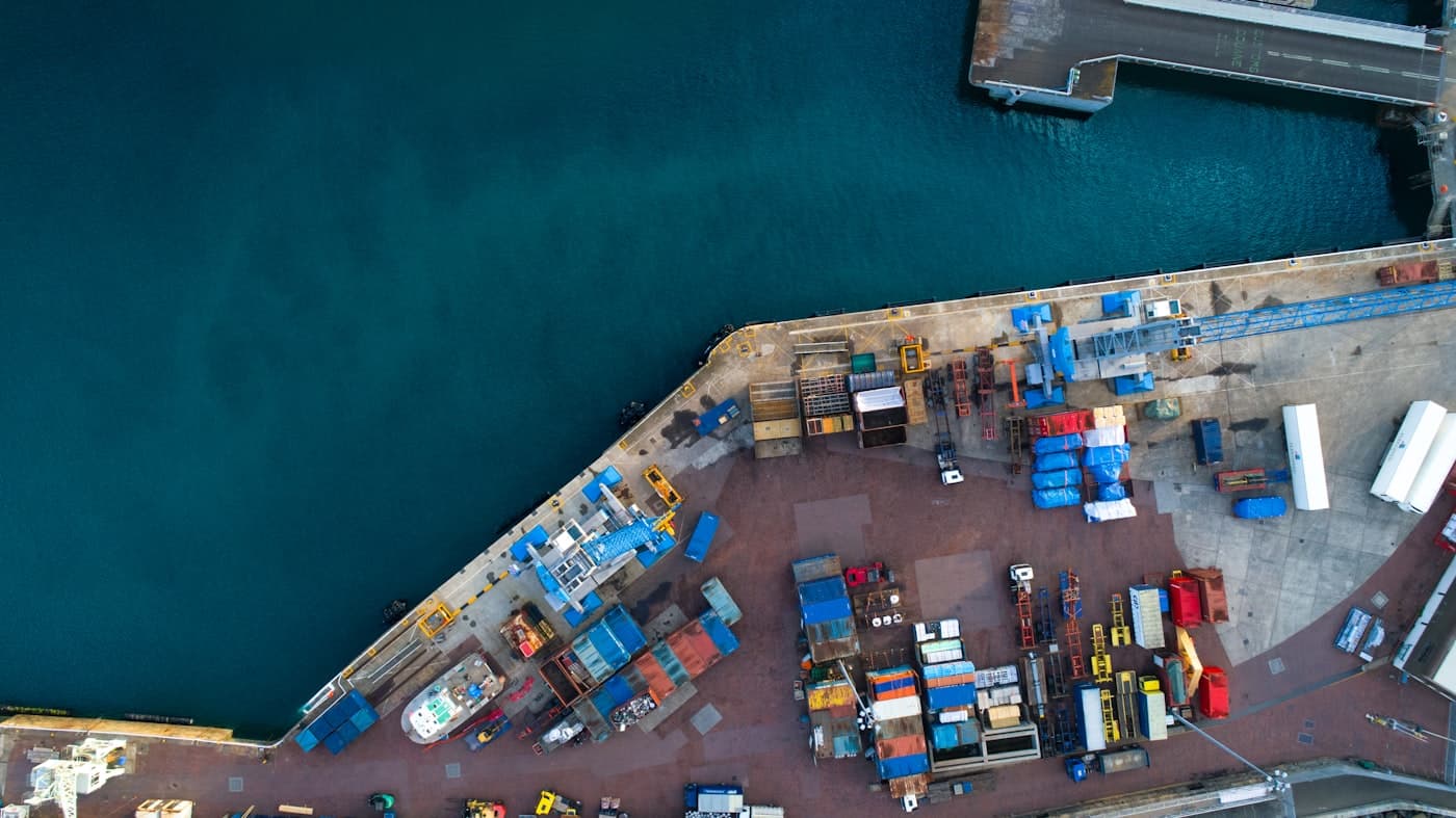 Vue aérienne de conteneurs alignés le long d'un quai portuaire